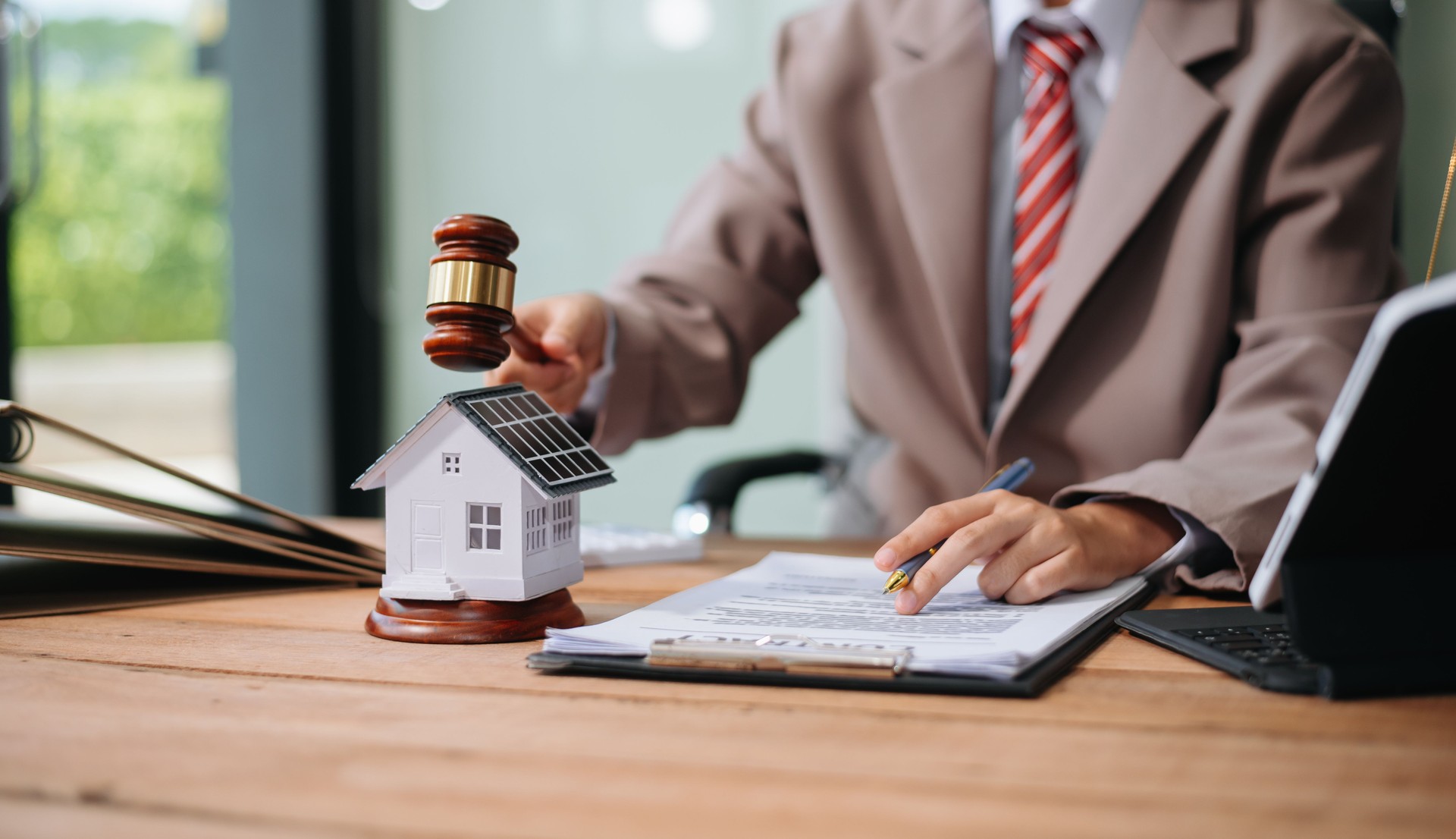 Real Estate Lawyer And House Foreclosure Law. House model, hammer judge gavel on table with white background.
